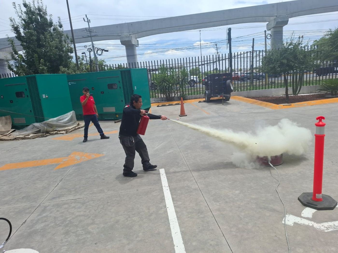 Práctica con extintor en estacionamiento de empresa