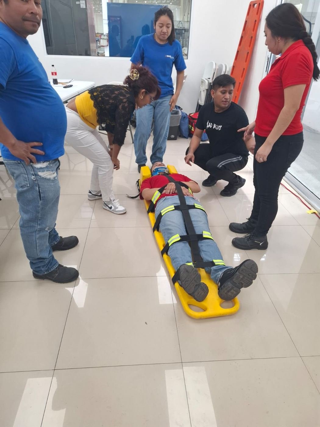 Brigada trasladando a un compañero en camilla rígida